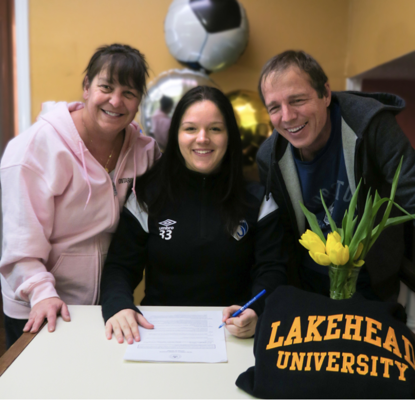 Abbygayle Welch Signs Soccer Contract Abbygayle Welch sits a table with a pen, with her parents on either side of her, and prepares to sign her Lakehead soccer contract