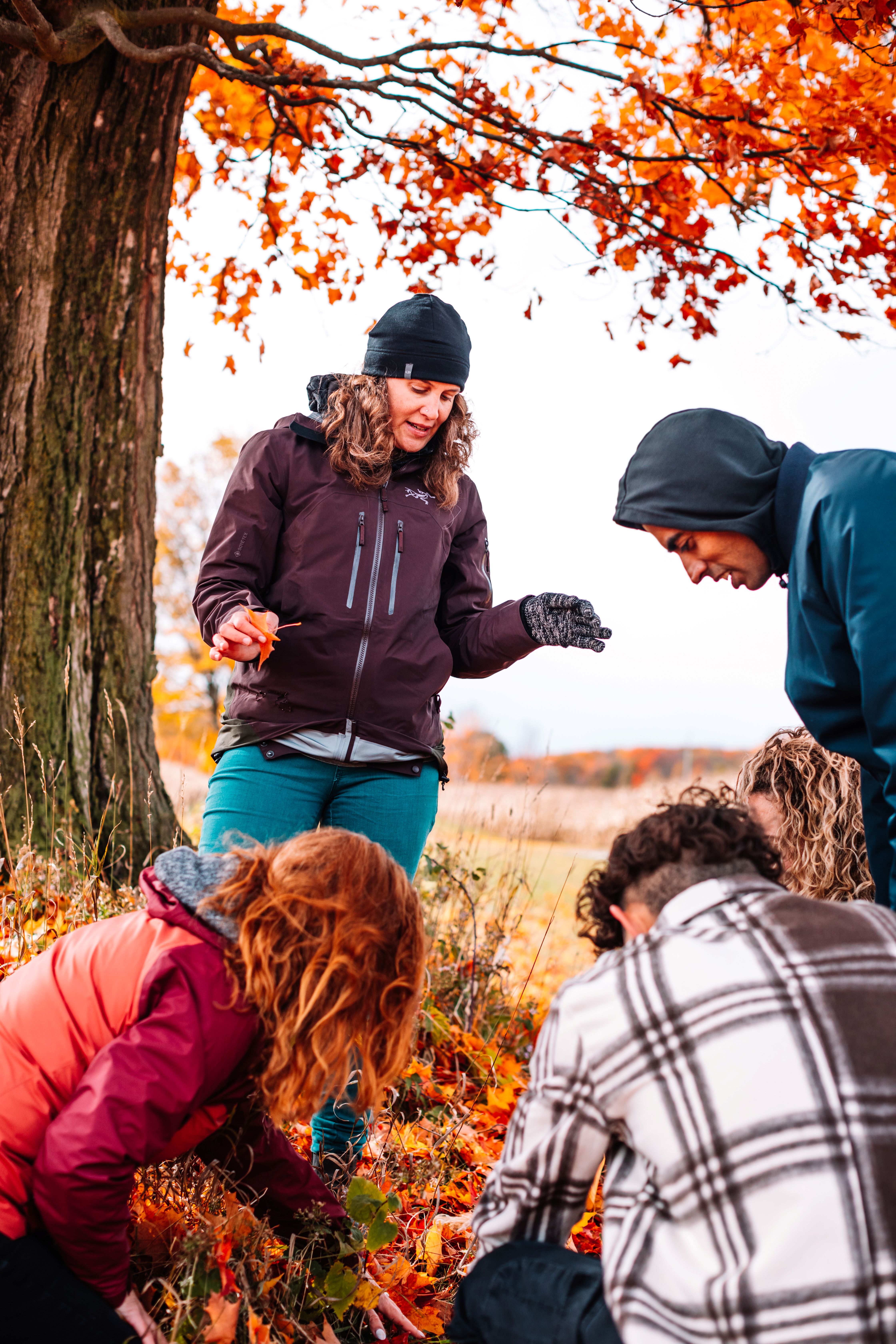Dr. Ellen Field with Lakehead Orillia Students Dr. Ellen Field outdoors with students looking at autumn leaves
