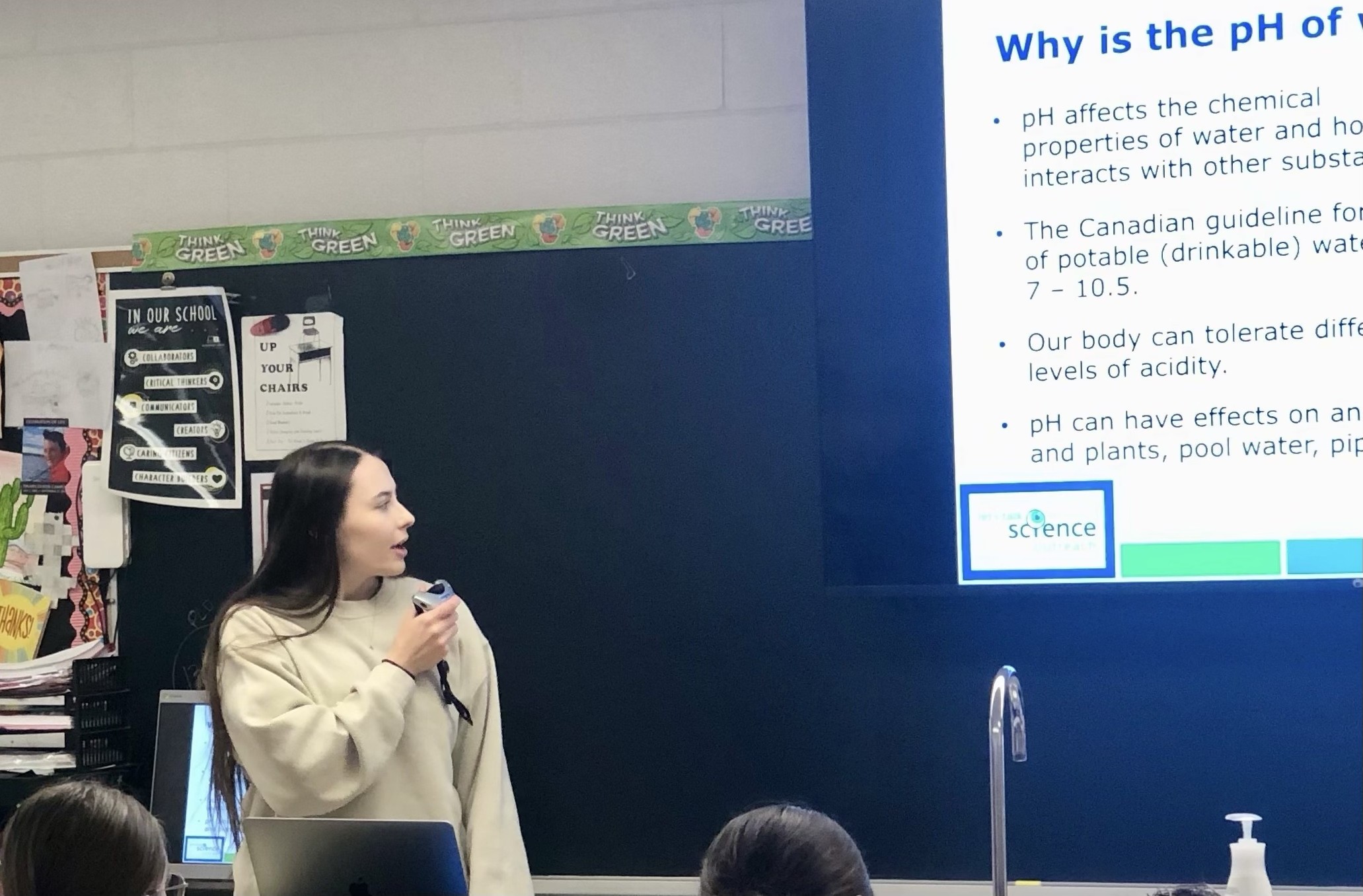 Let's Talk Science Volunteering Bianca Zussino stands in front of a chalkboard while giving a presentation in an elementary school classroom