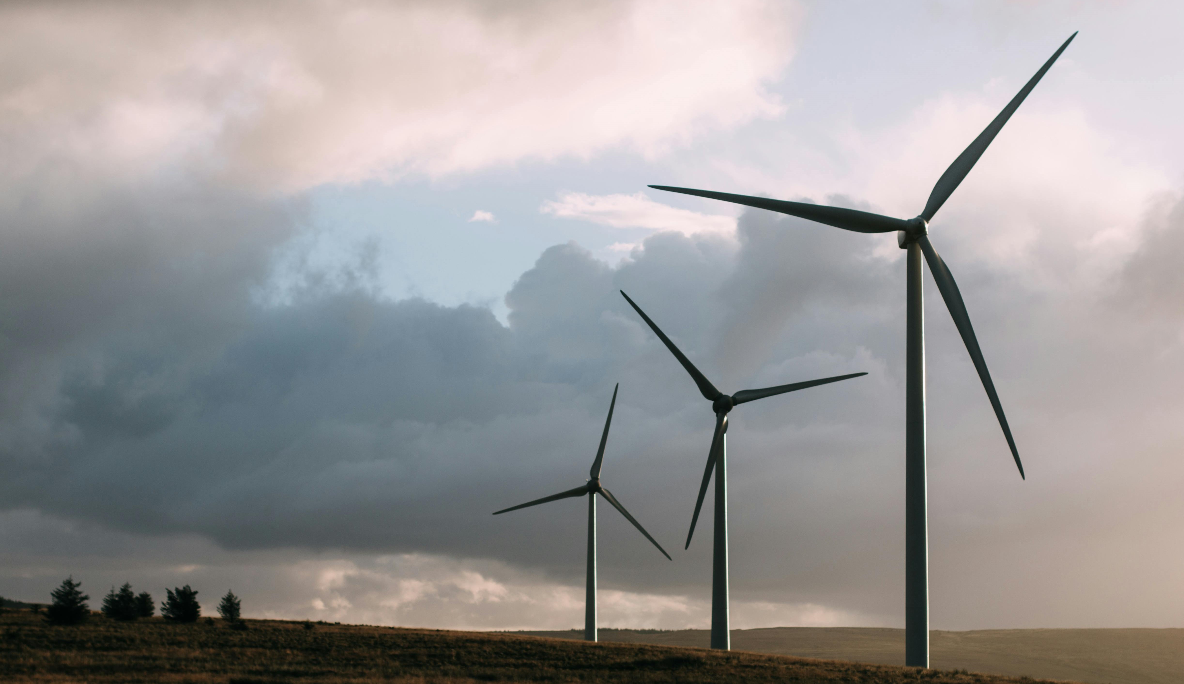 Wind Turbines Three wind turbines in an open field on a cloudy day