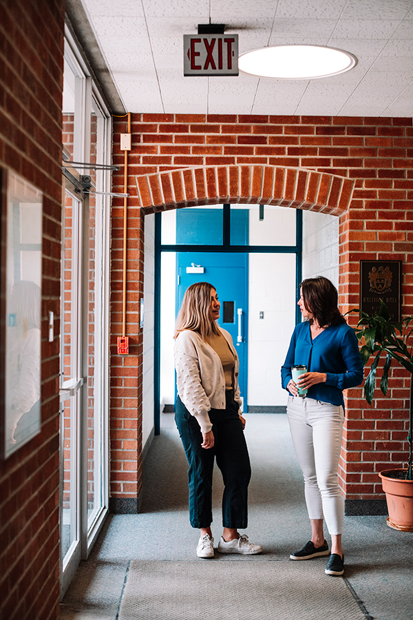 Staff members speaking in a hallway