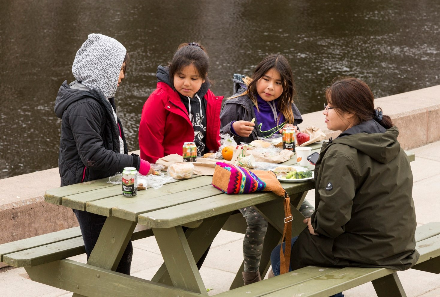 Children in the Achievement Program having lunch at a picnic table on Thunder Bay campus