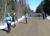 Group of people walking along a dirt road with snow banks