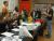 A group of high school students sitting at the lab desk, listening to an instructor