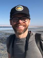 Image of Dr. Adam Algar in front of some flamingos