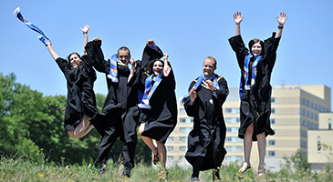 Students celebrating in graduation gowns