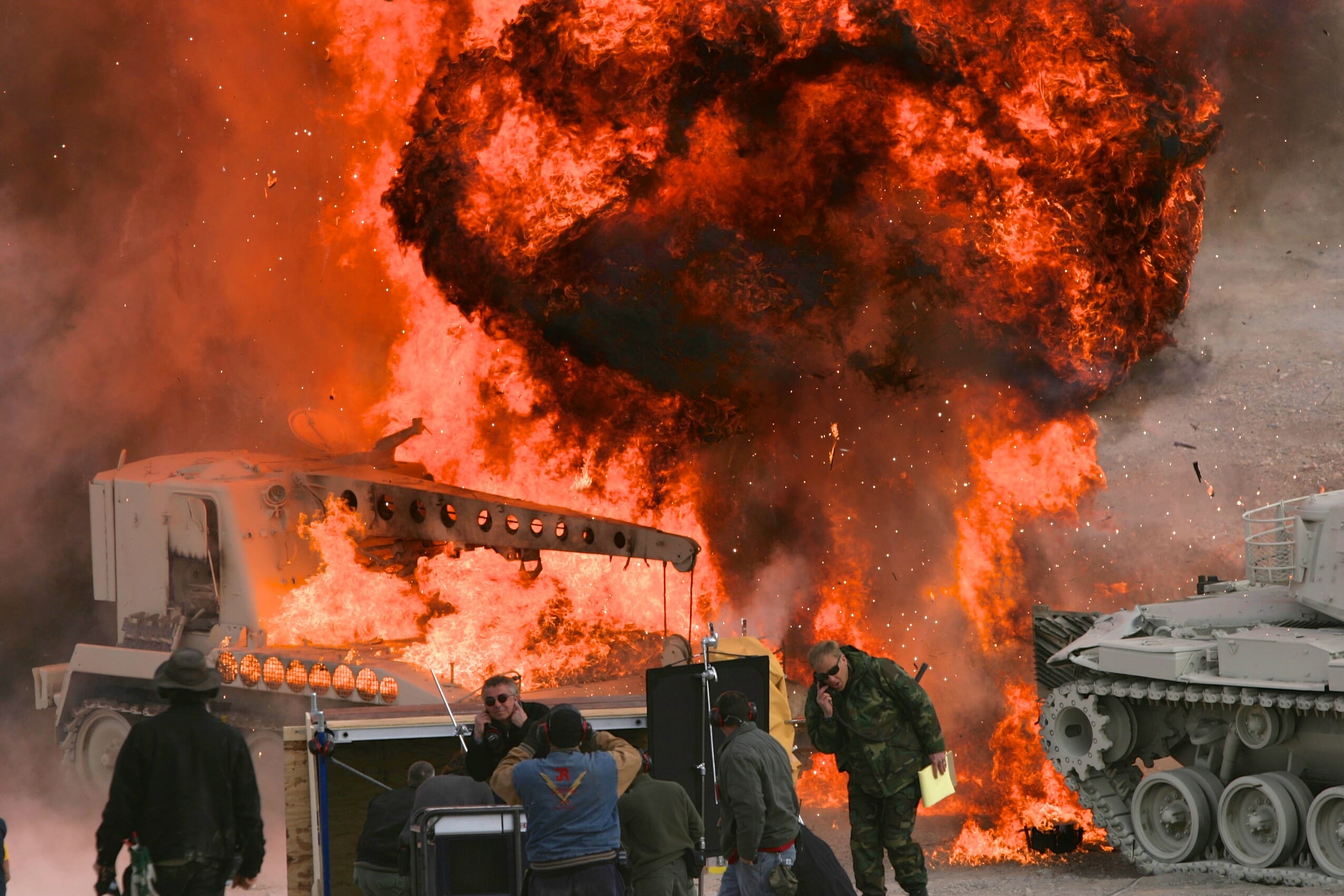 Stephen Low on a movie set with tanks on fire