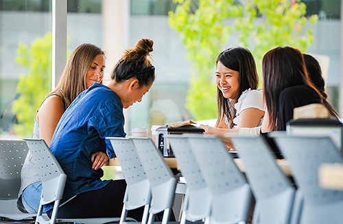 Students sitting around a table laughing in the Orillia cafeteria